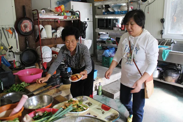 서울서 온 손님이 부엌일을 거들고 있다.