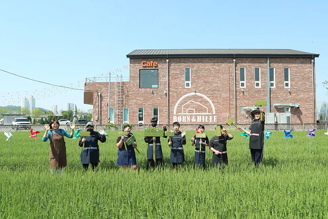 농촌돌봄농업 프로그램에 참여한 고산중 아이들과 정선진 대표가 손을 흔들고 있다.