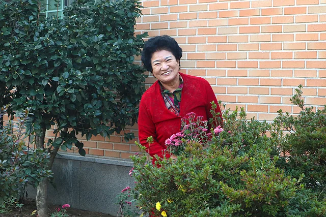 #화단에서 활짝 웃고 있는 홍영애 어르신