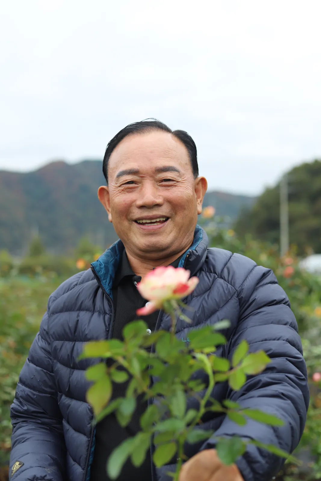 꽃을 내밀며 웃는 신재수 씨