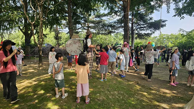 유랑극단 '극딴'의 단원들이 사람들을 이끌고 함께 걷고 춤추며 축제의 즐거움을 나누고 있다.