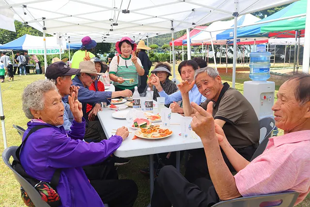 음식을 함께 나누며 즐거워하는 지역 어르신들